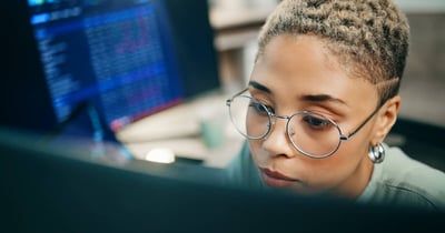 woman concetrating with multiple monitors